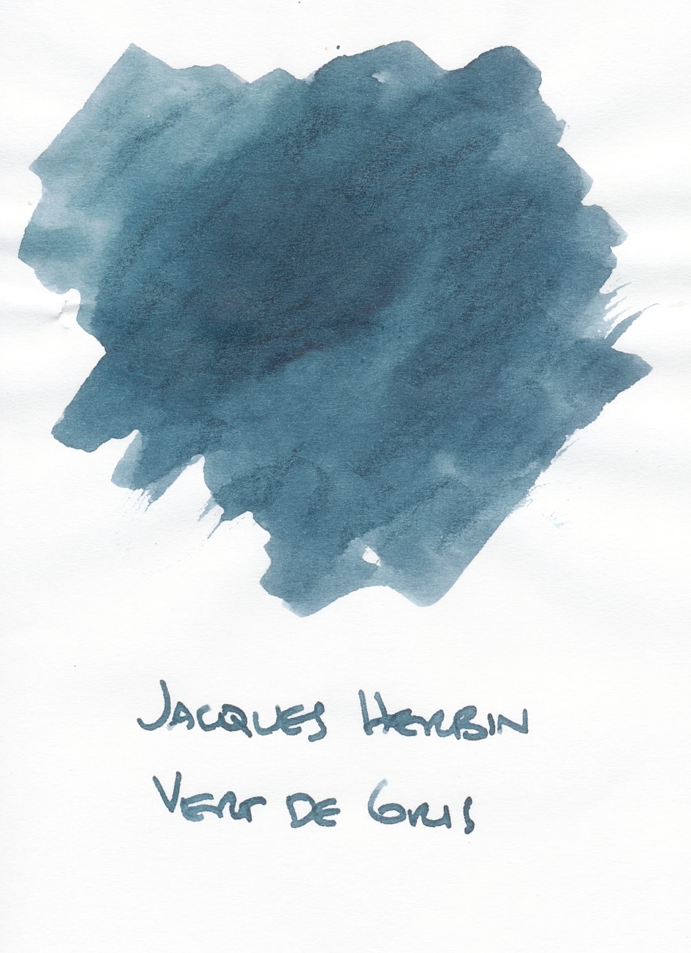 Fountain pen ink swatch on white paper, a grayish blue-green shade with the writing "Jacques Herbin Vert de Gris" underneath