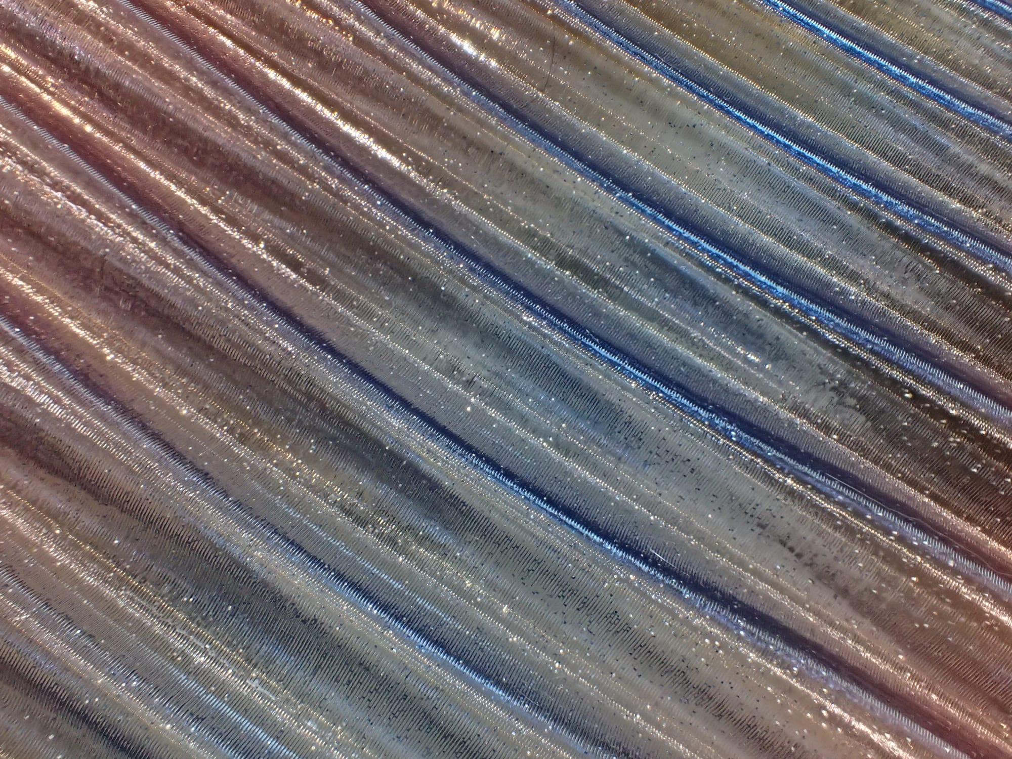 Macro of the pen tray better showing the translucency and glitter of the pen tray, the peach to blue to peach gradient visible from top left to bottom right corner