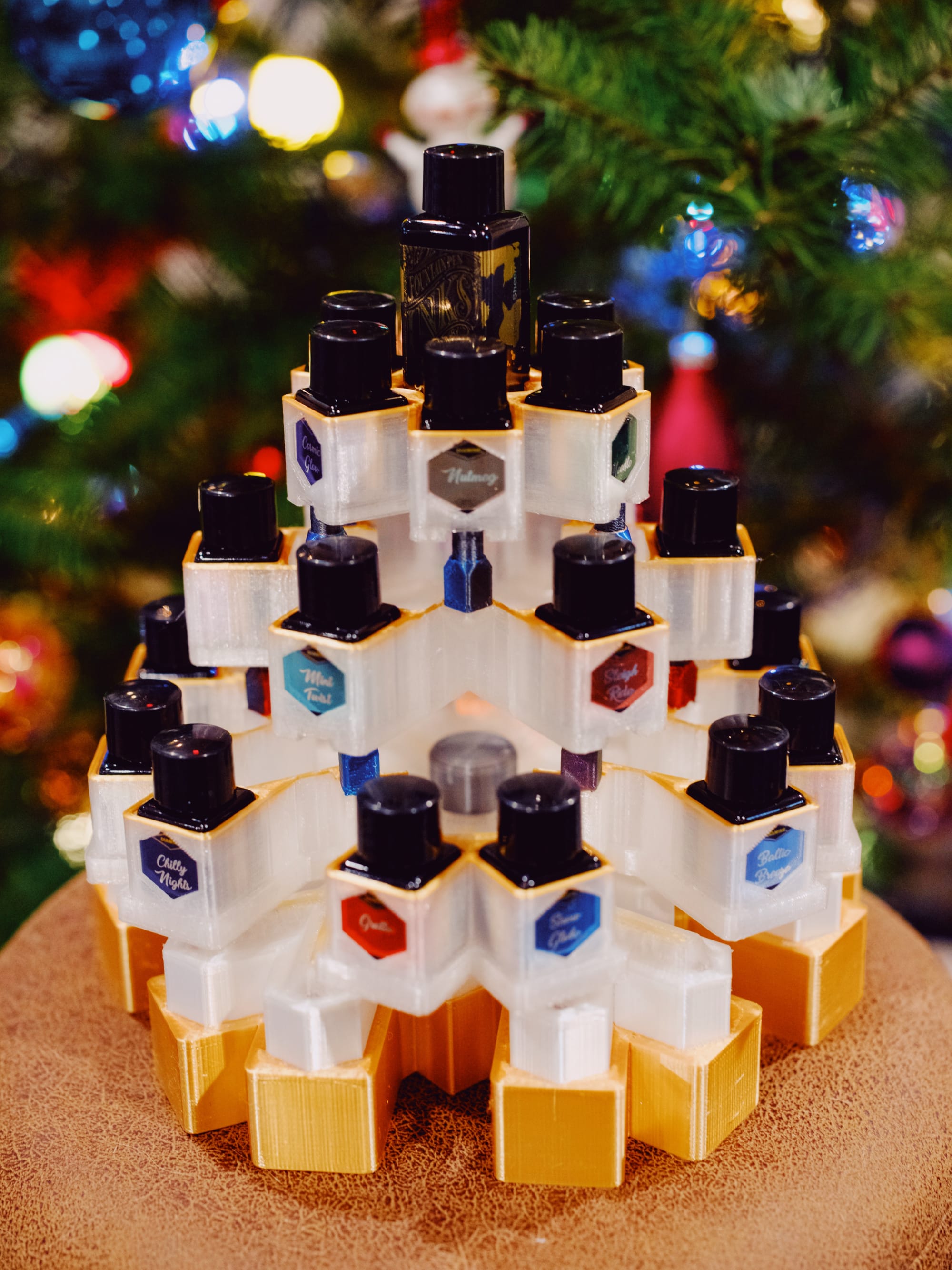 Snowflake box's three tiers assembled into a kind of Christmas tree shape, sitting on top of the box lid