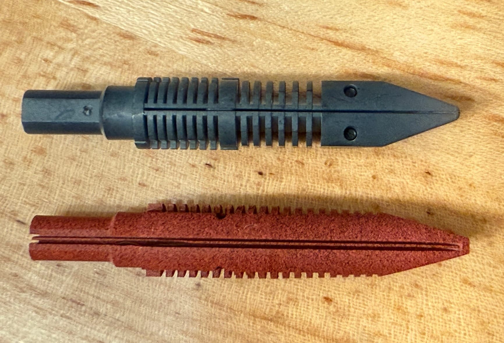 Overhead view of a black plastic feed from Pilot (top) and the red ebonite feed from Flexible Nib Factory with 2 significantly deeper slits carved into it (bottom)