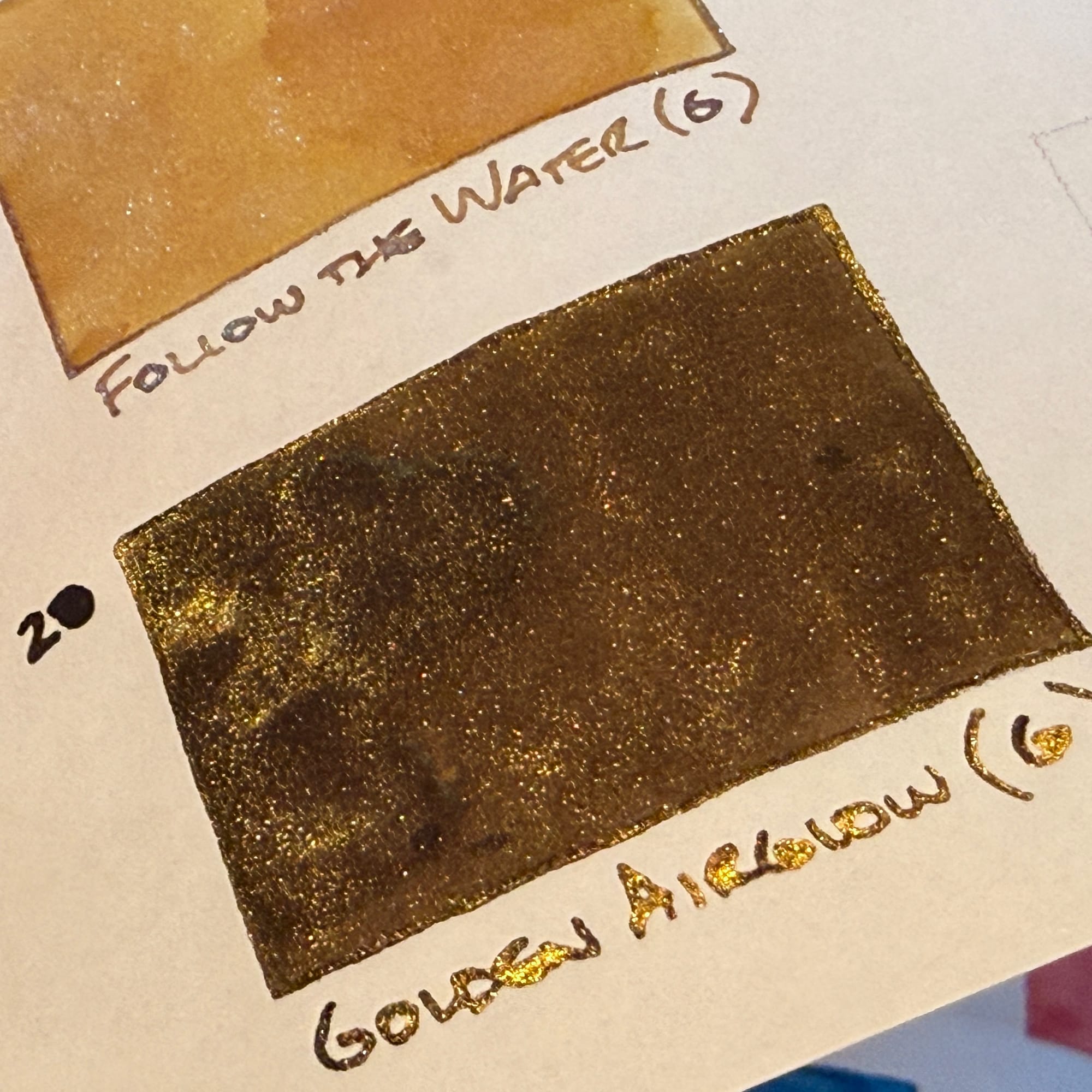 Fountain pen ink swatch of a dark brown ink with gold shimmer, labeled "Golden Airglow (g)"