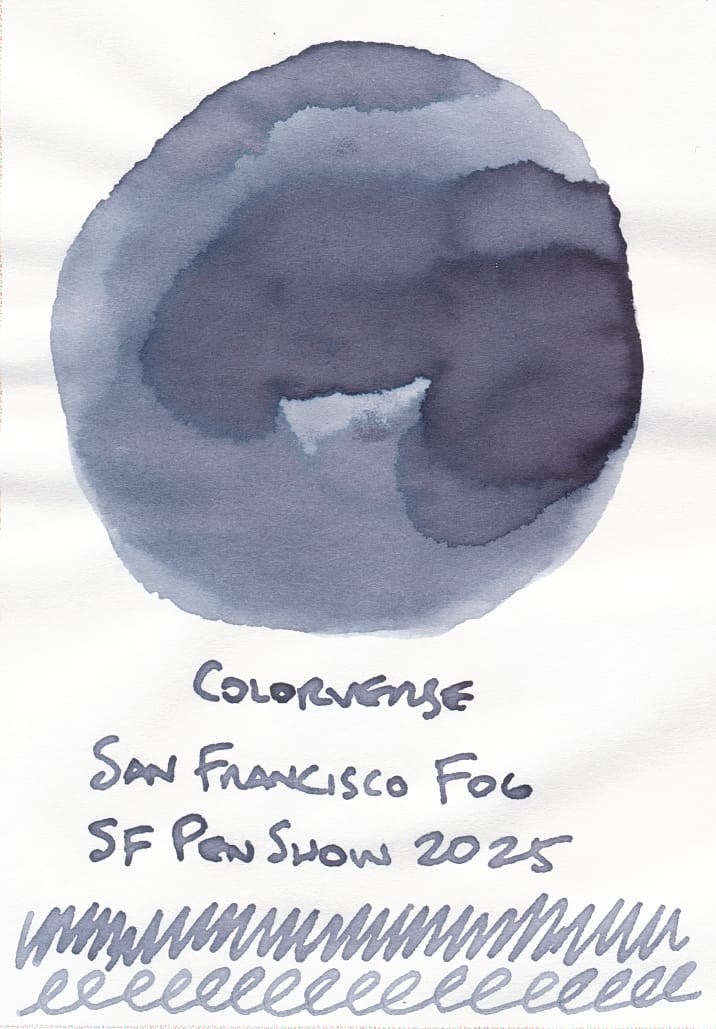 Fountain pen ink swatch - a round swatch showing different levels of shading of a foggy blue-gray ink, labeled "Colorverse San Francisco Fog; SF Pen Show 2025" underneath