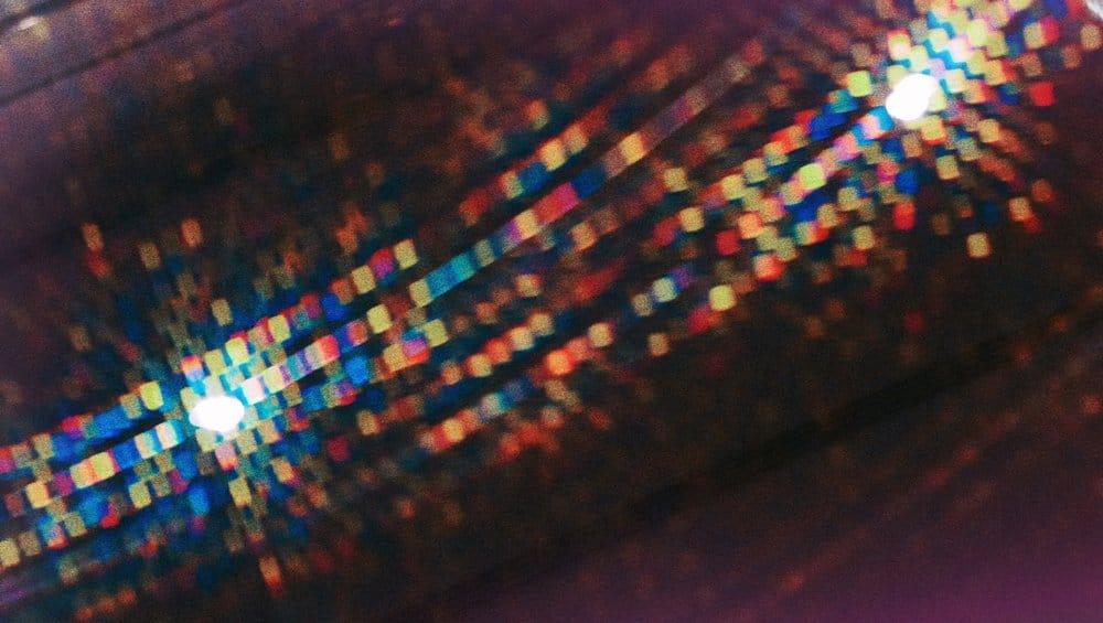 Abstract macro picture of some refraction patterns in a car bumper showing a myriad of tiny colorful squares