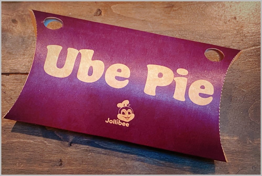 Purple outer packaging of Jollibee's ube pie, "Ube Pie" in large letters, and a smaller Jollibee logo beneath