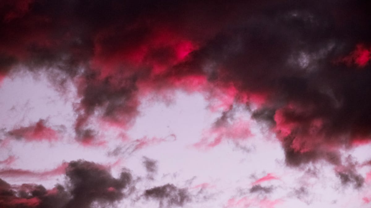 Dramatic clouds at sunset, very dark gray with deep pink highlights