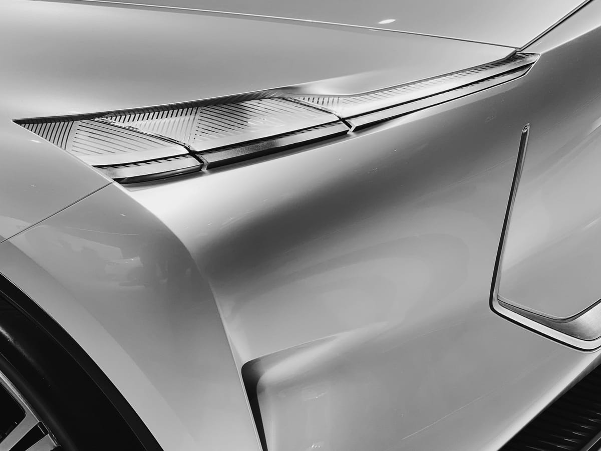 Monochrome close up of a concept car's headlights which look like clear glass slats stacked together in a slot on the hood