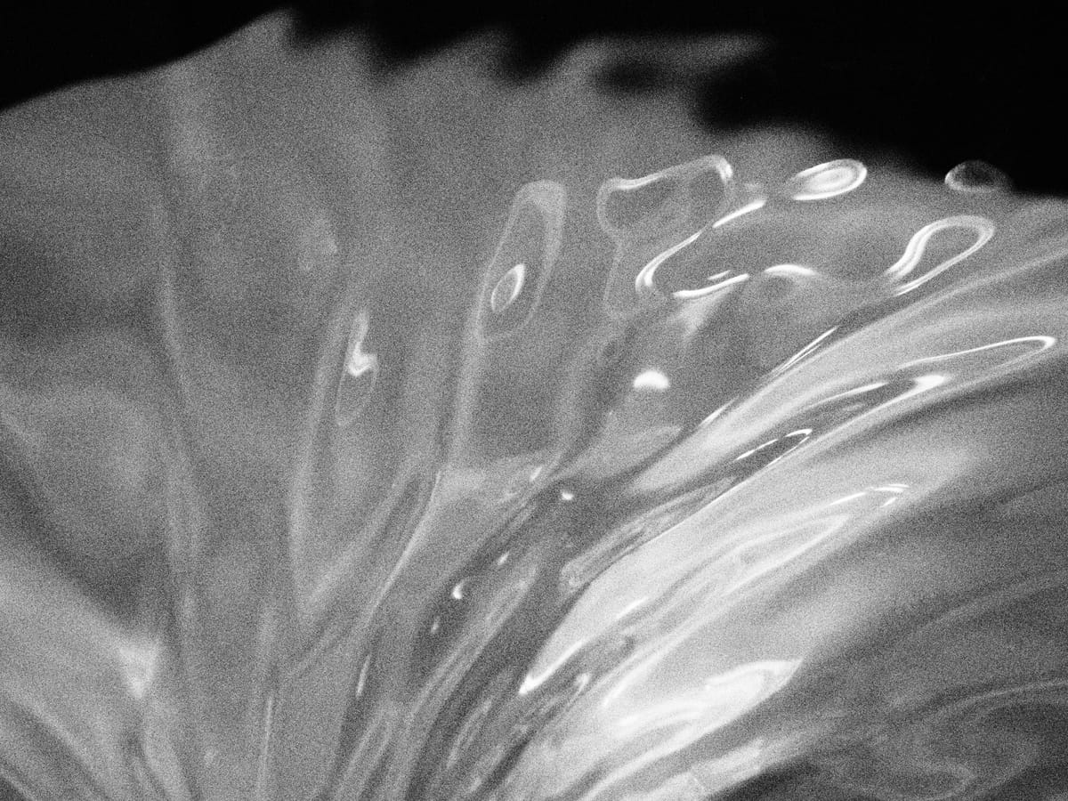 Black and white, grainy, macro abstract image of rippling water