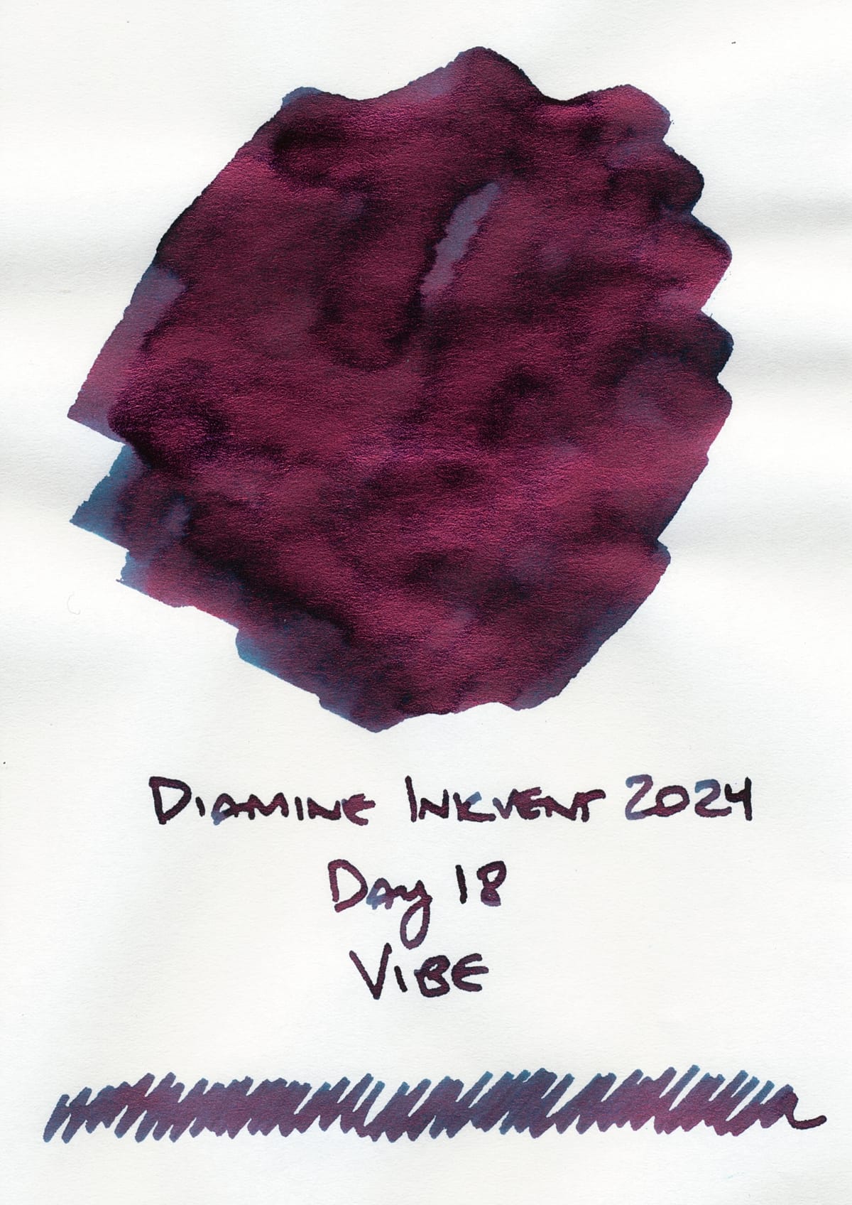 Fountain pen ink swatch of a dark teal ink with a shiny red sheen overlaid, "Diamine Inkvent 2024; Day 18; Vibe"